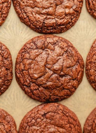 Rows of brownie cookies on brown parchment paper.