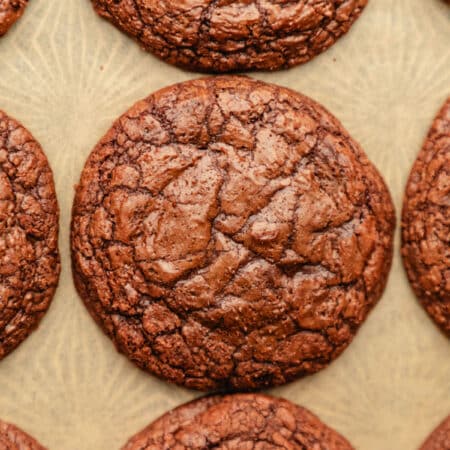 Rows of brownie cookies on brown parchment paper.