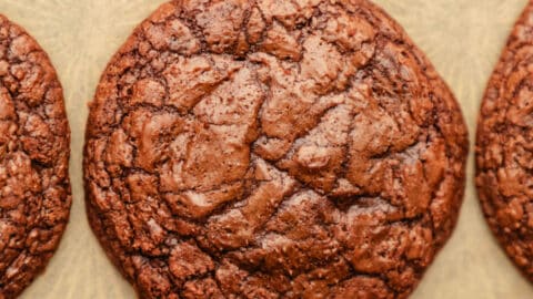 Rows of brownie cookies on brown parchment paper.