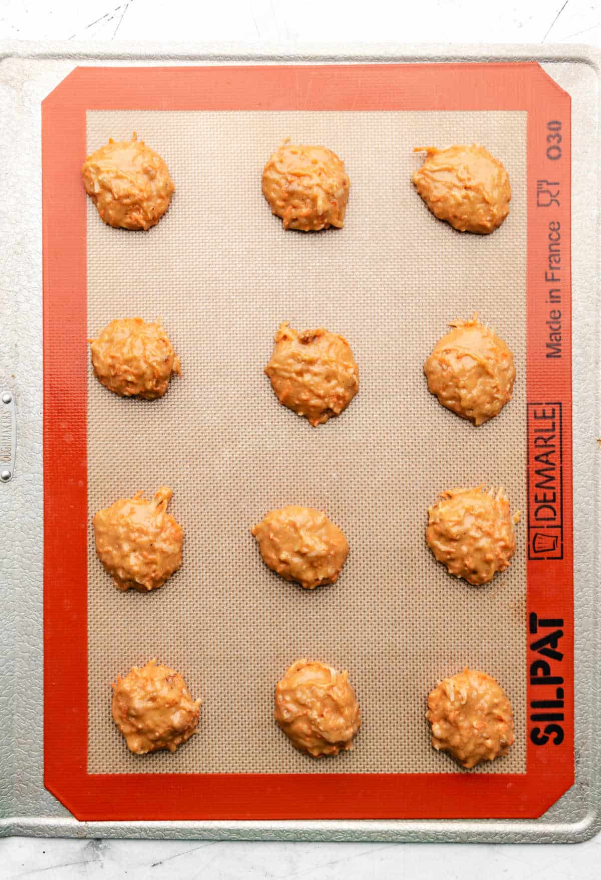 Unbaked carrot cake cookies on a baking sheet. 