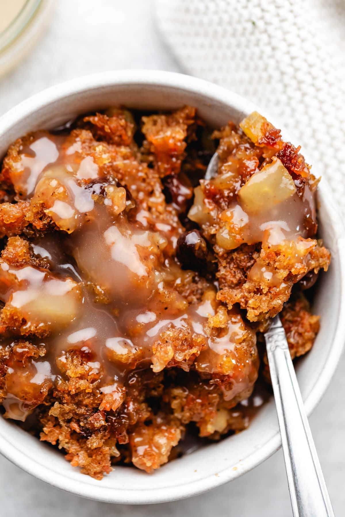 Close up photo of a spoon holding a bite of steamed carrot pudding.