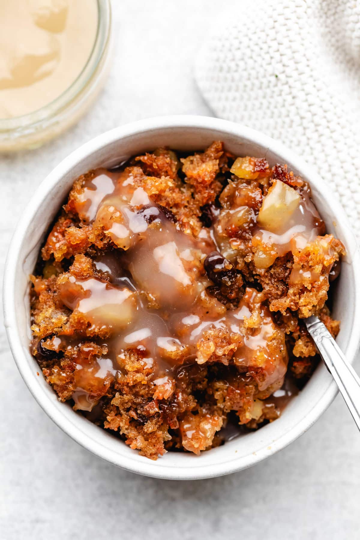 Overhead photo of a spoon holding a bite of carrot pudding in the dish.