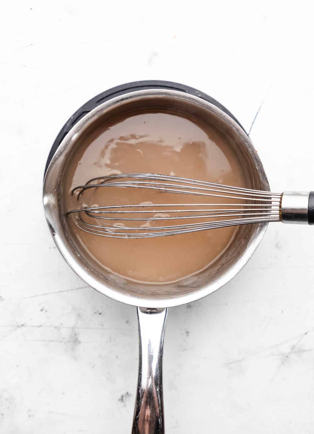 Vanilla sauce for steamed pudding in a silver saucepan.