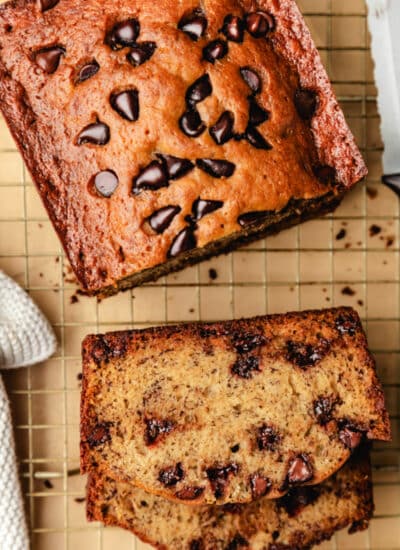 Slices of chocolate chip banana bread next to the rest of the loaf.