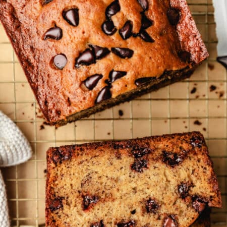 Slices of chocolate chip banana bread next to the rest of the loaf.