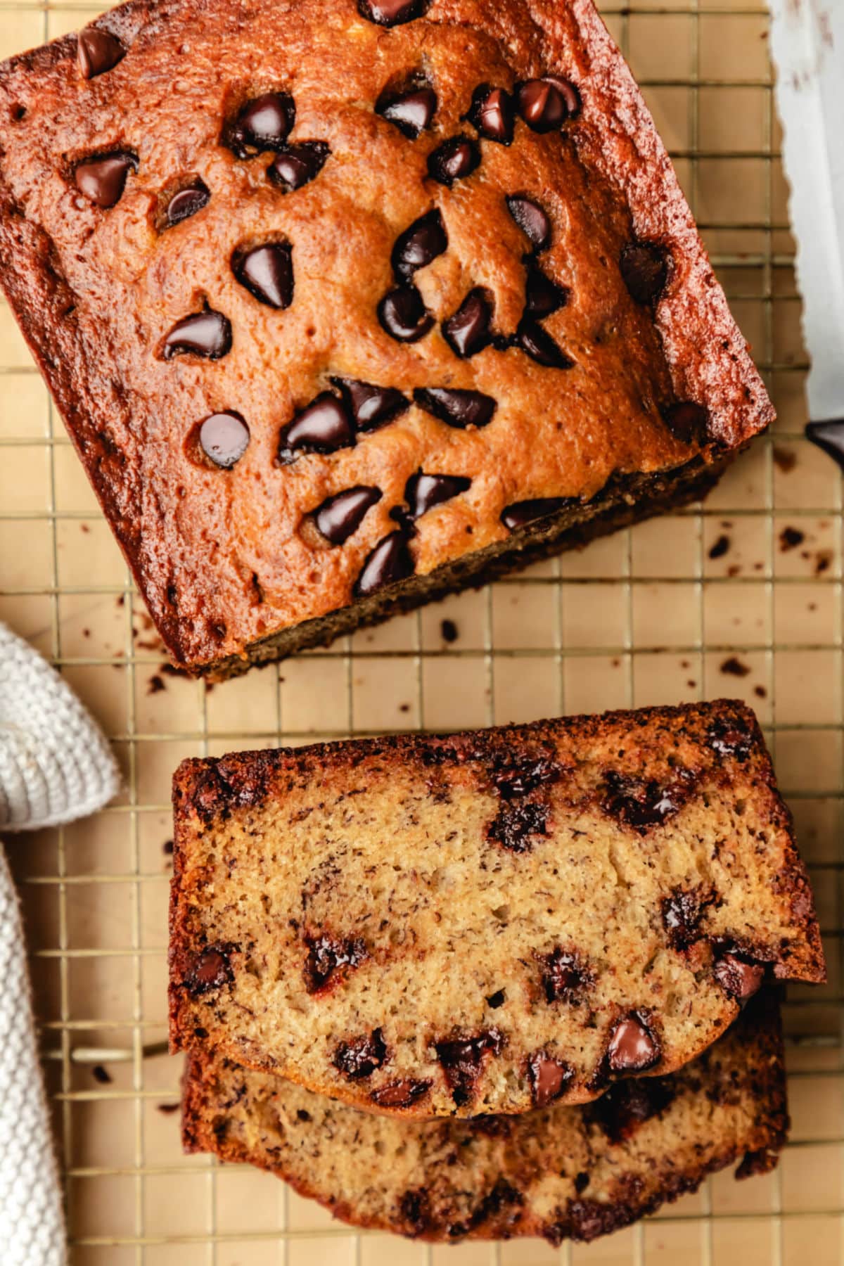 Slices of chocolate chip banana bread next to the rest of the loaf.