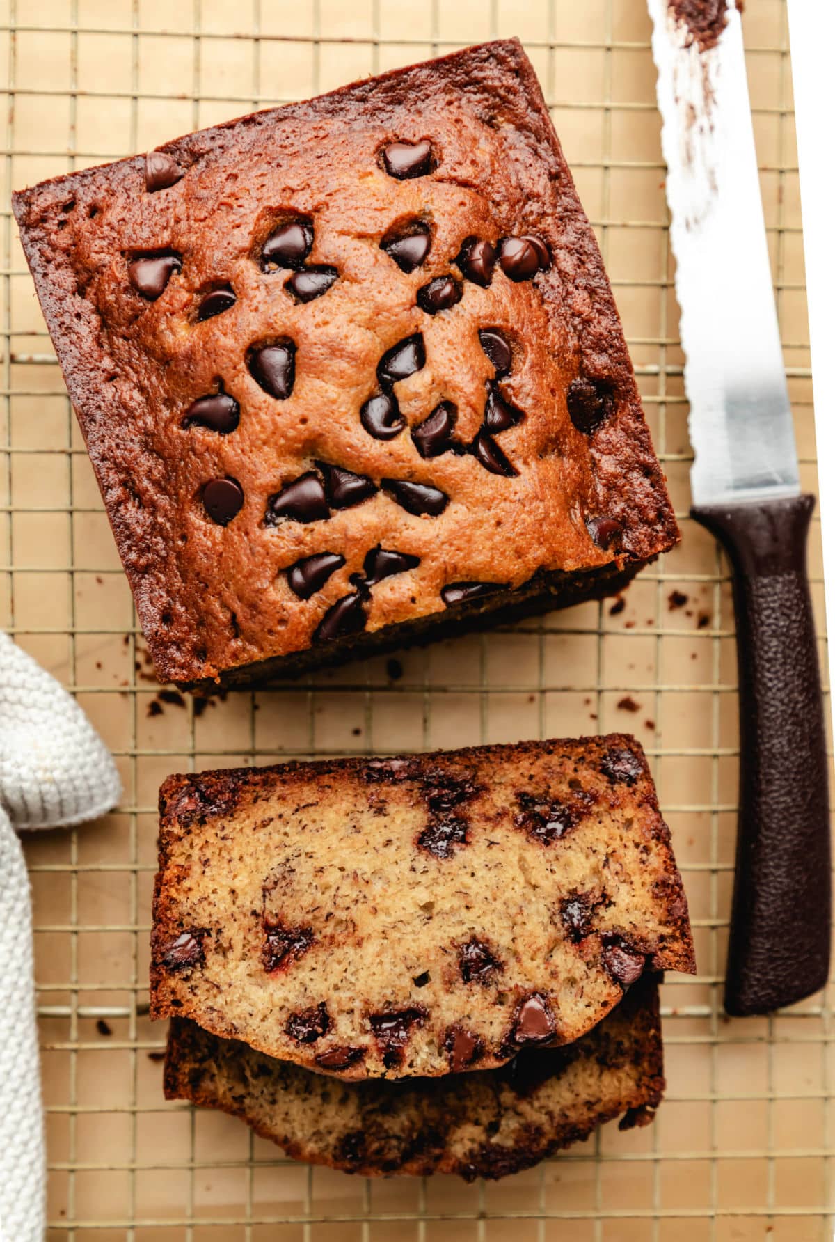 Two sliced pieces of chocolate chip banana bread next to the loaf. 