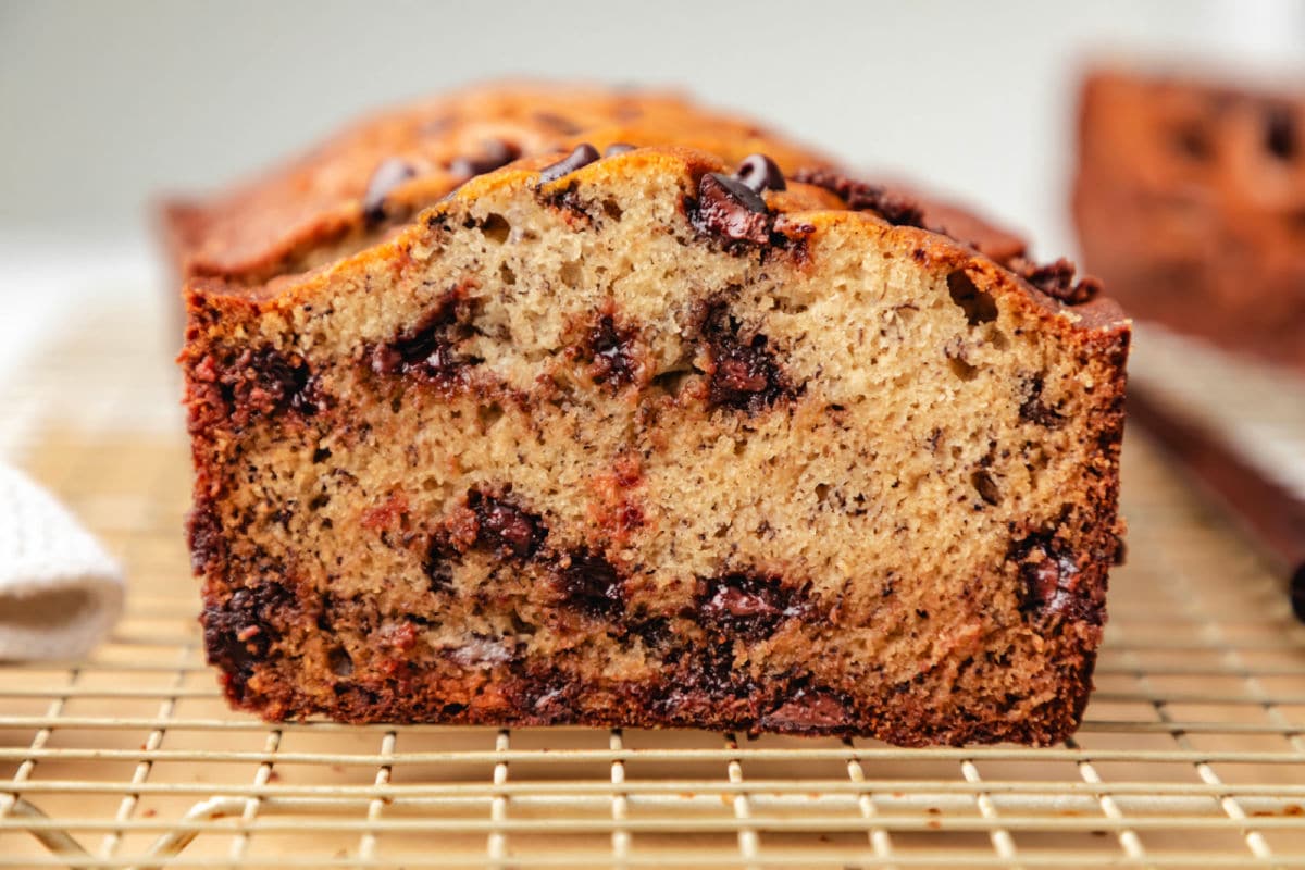 Upright slices of chocolate chip banana bread on a wire rack. 