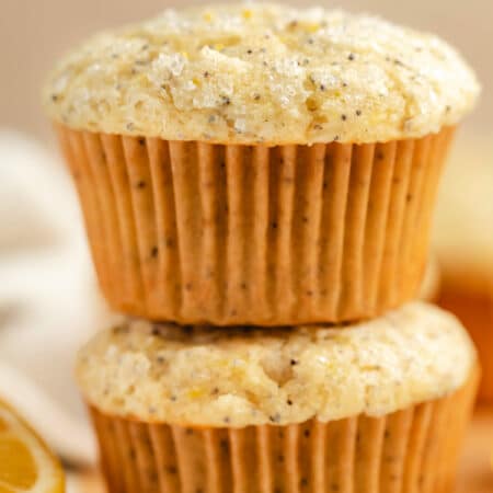 Two lemon poppy seed muffins stacked on top of each other.