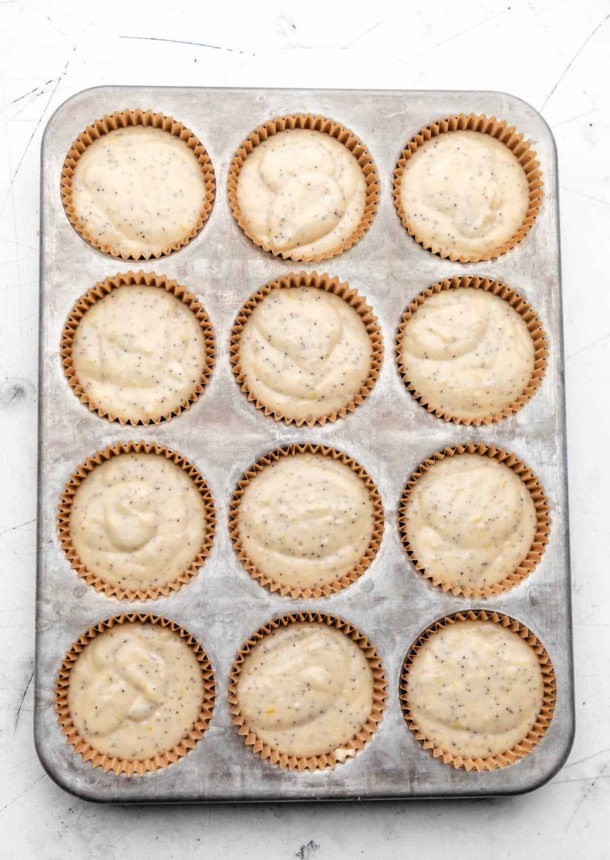 Lemon poppy seed batter in a muffin tin. 