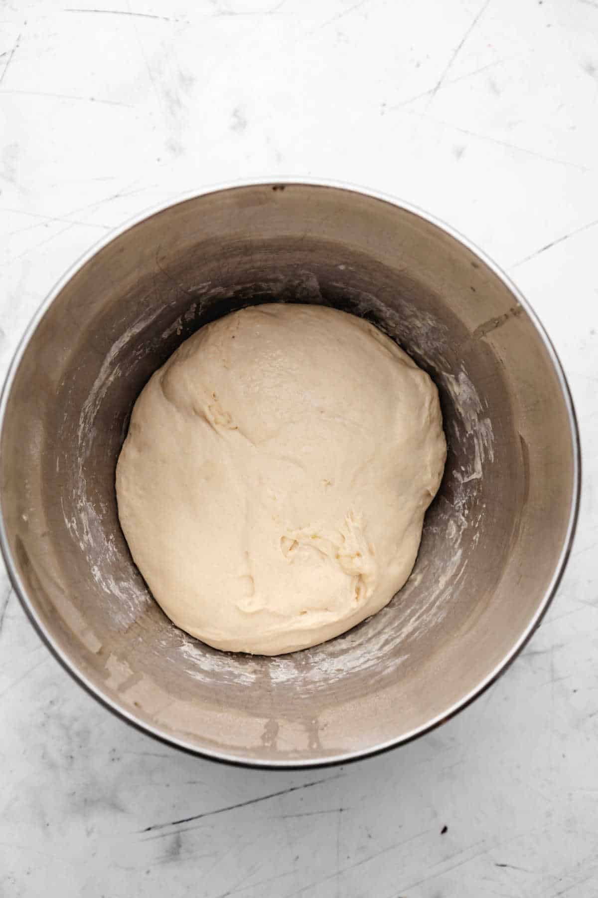 Skillet bread dough in a silver mixing bowl.