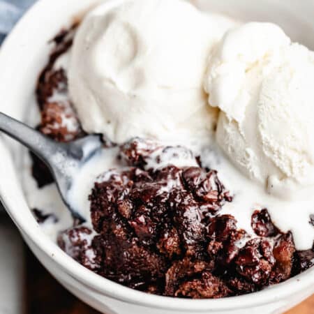 A spoon scooping up a bite of crock pot triple chocolate bread pudding.