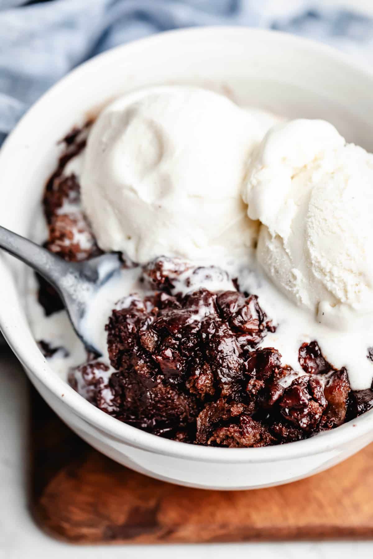 A spoon scooping up a bite of crock pot triple chocolate bread pudding.