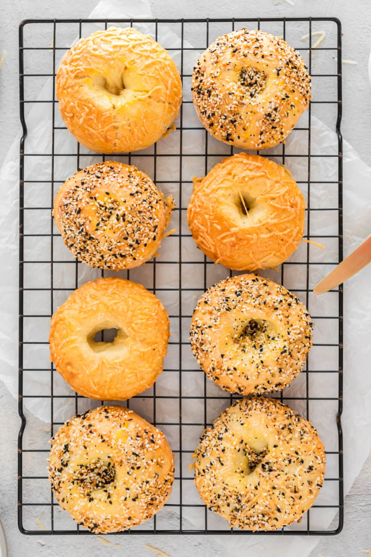 Eight baked 3 ingredient bagels on a wire cooling rack.
