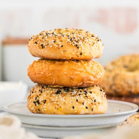 Three 3 ingredient bagels stacked on a white plate.