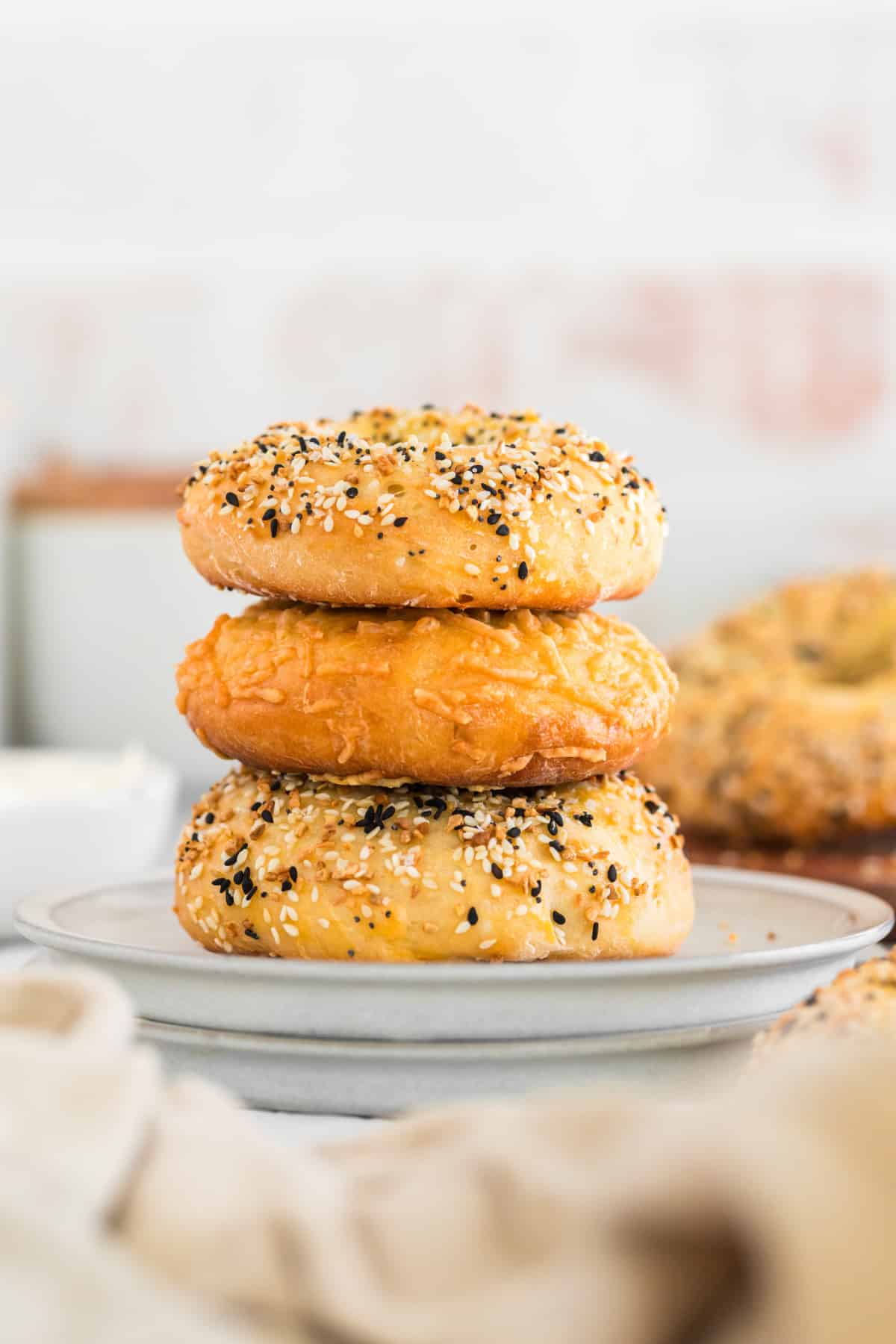 Three 3 ingredient bagels stacked on a white plate. 