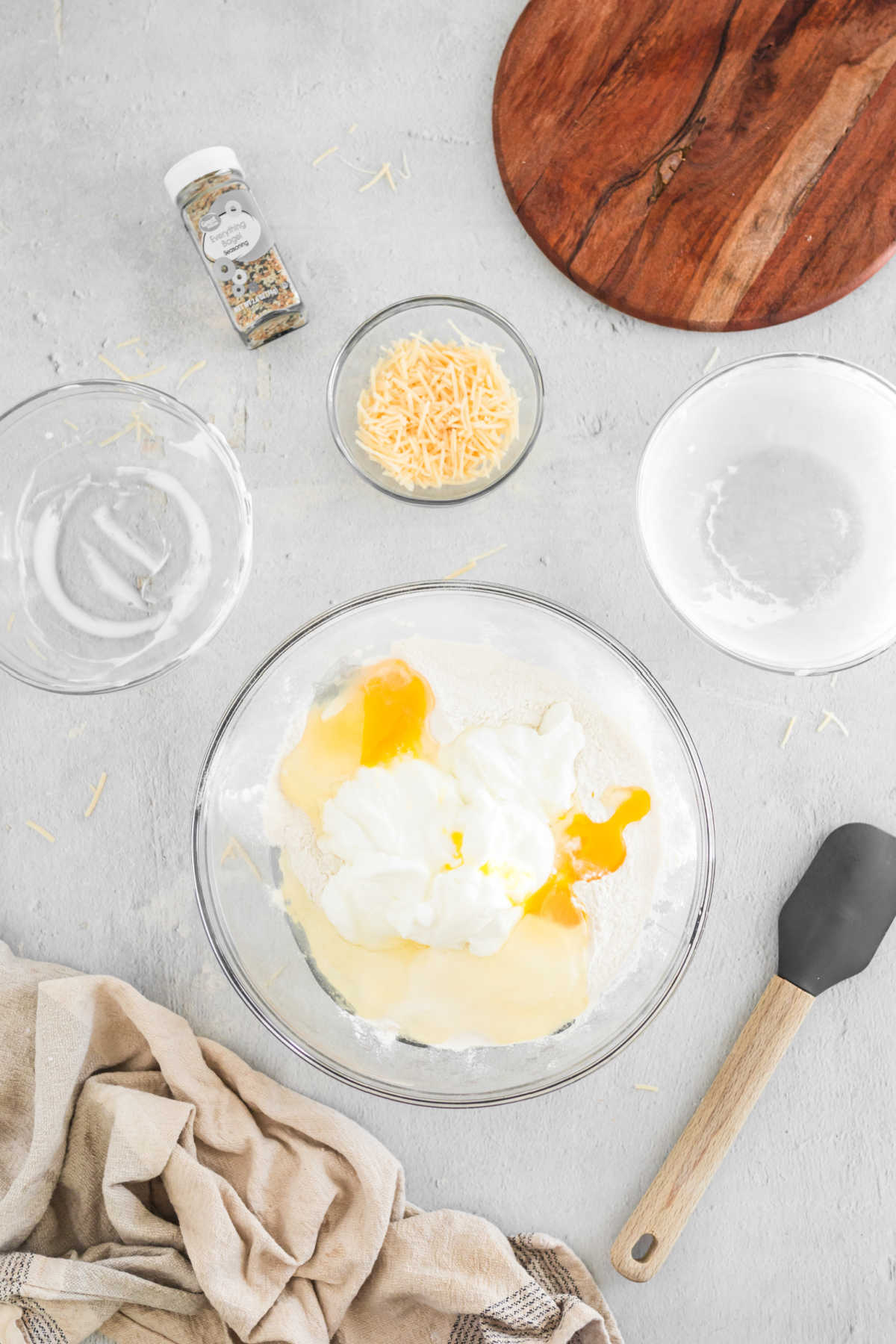 Greek yogurt, flour, and eggs in a glass mixing bowl.