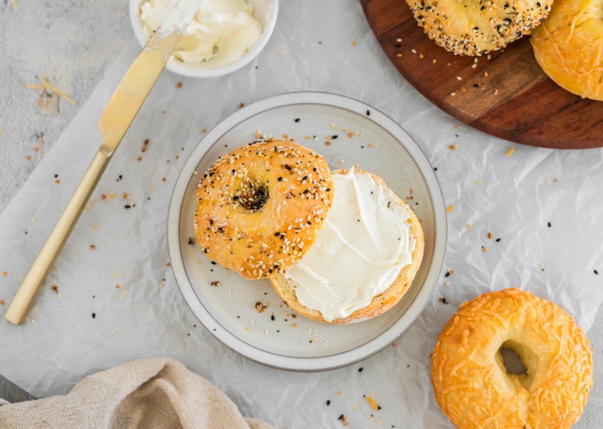 A sliced bagel with cream cheese on a plate. 