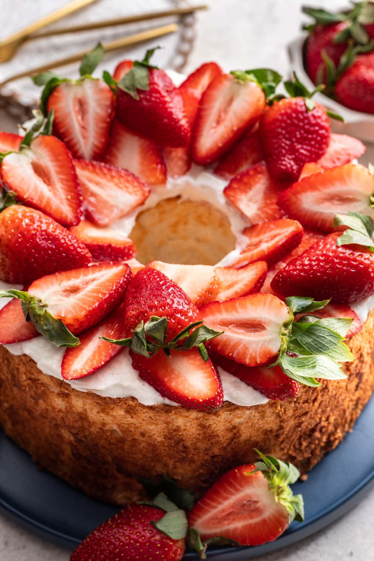 An angel food cake surrounded by fresh strawberries.