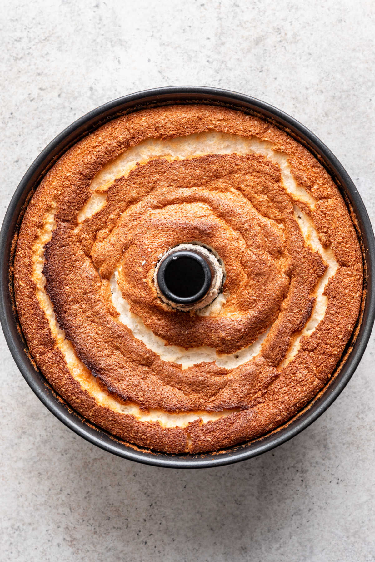 A baked angel food cake in a tube pan.
