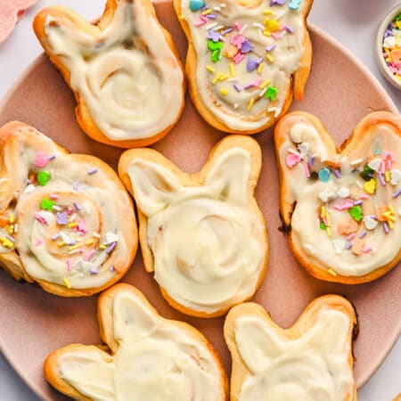 Easter bunny cinnamon rolls on a pink plate.