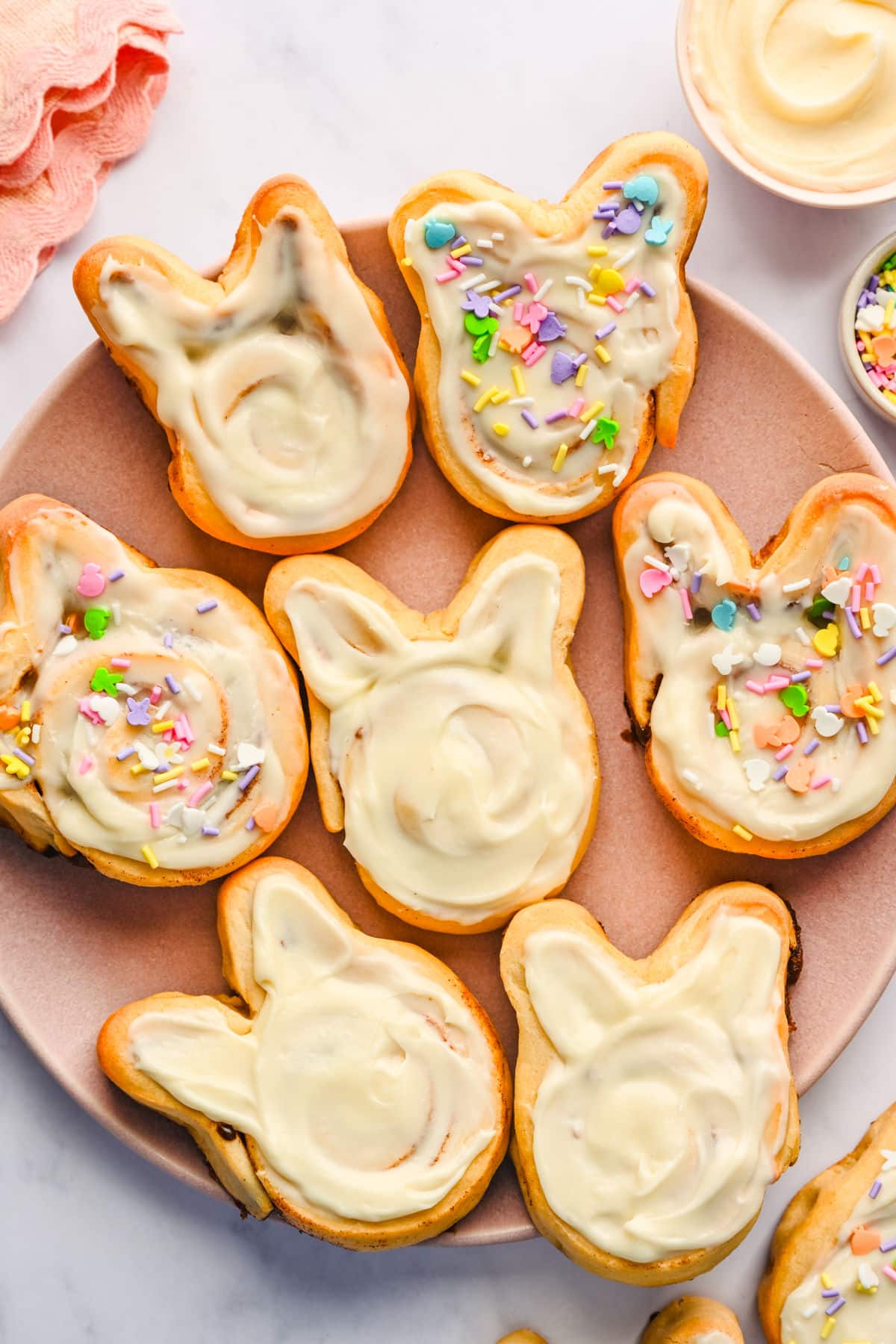 Easter bunny cinnamon rolls on a pink plate.