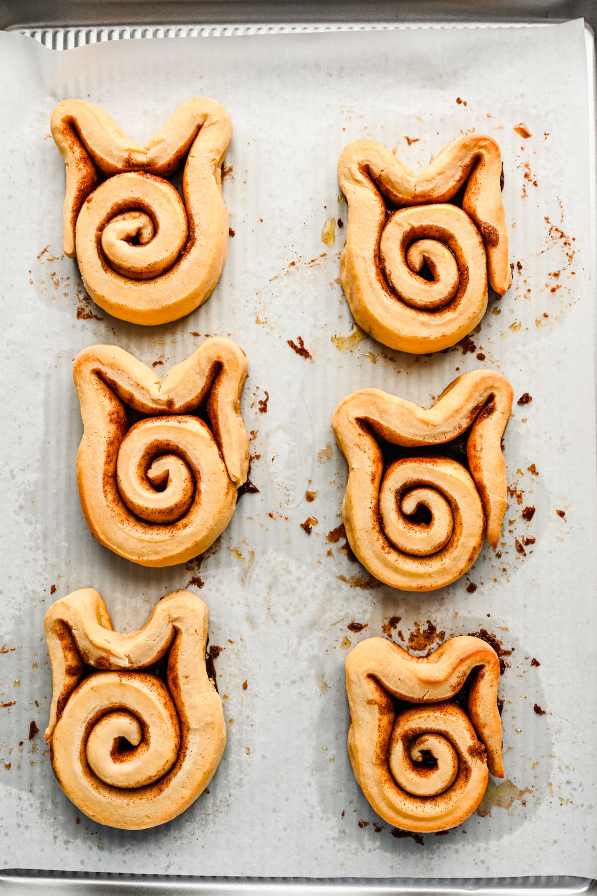 Risen Easter bunny cinnamon rolls on a baking tray.