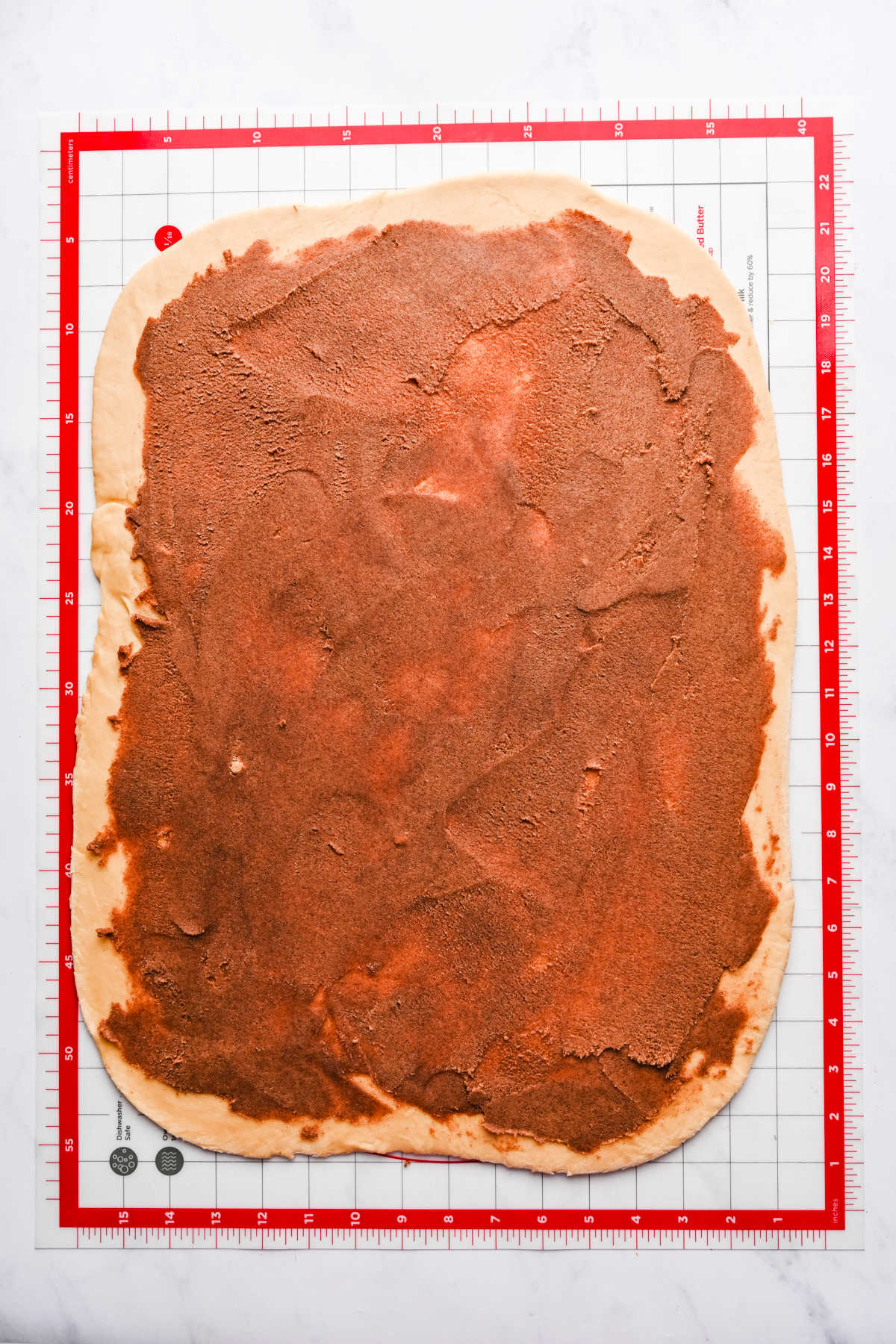Cinnamon roll filling spread over dough. 