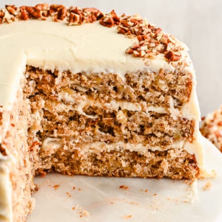 A cut section of hummingbird cake on a marble cake stand.