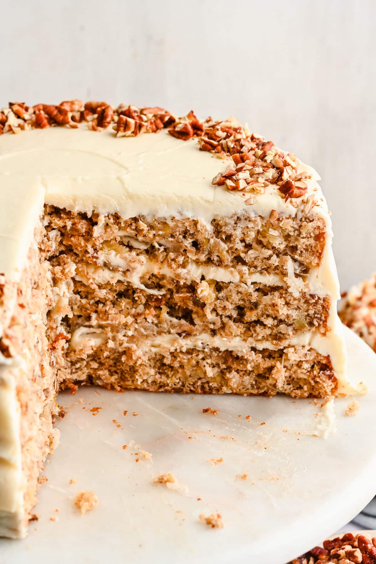 A cut section of hummingbird cake on a marble cake stand.