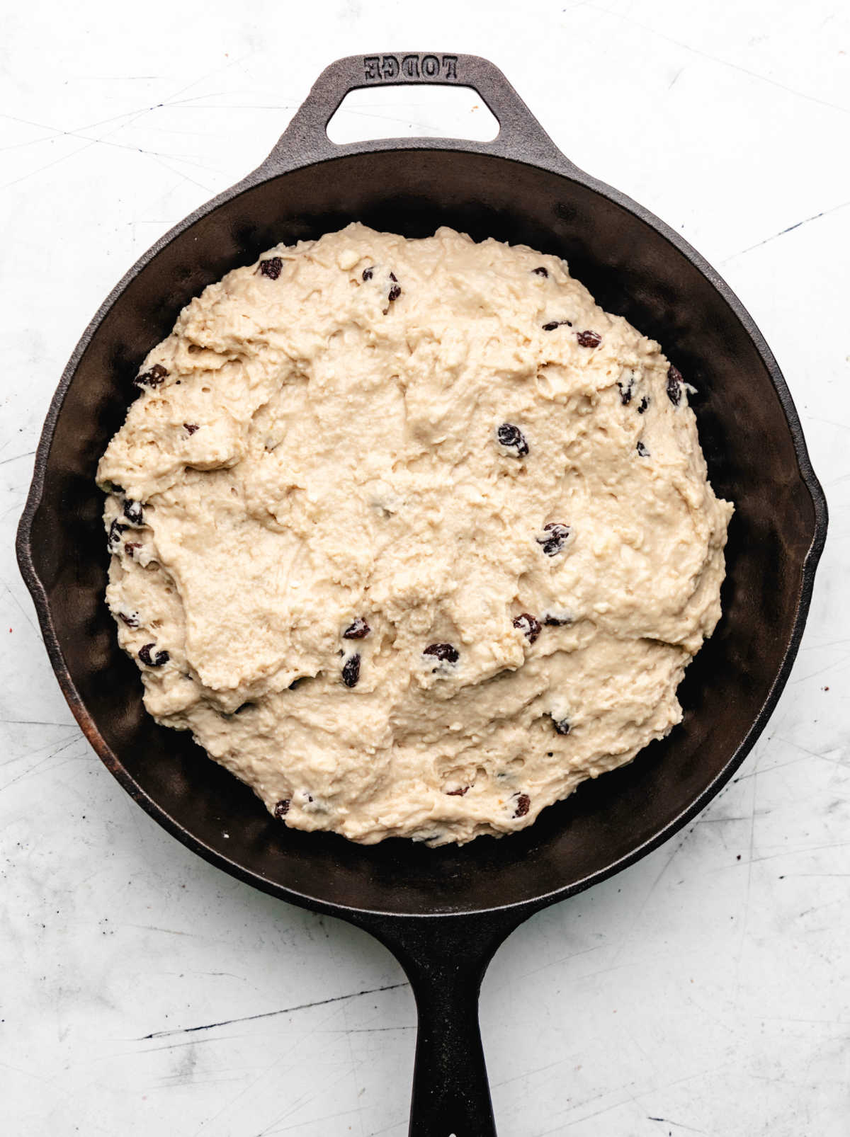 Irish soda bread dough spread in a cast iron skillet.