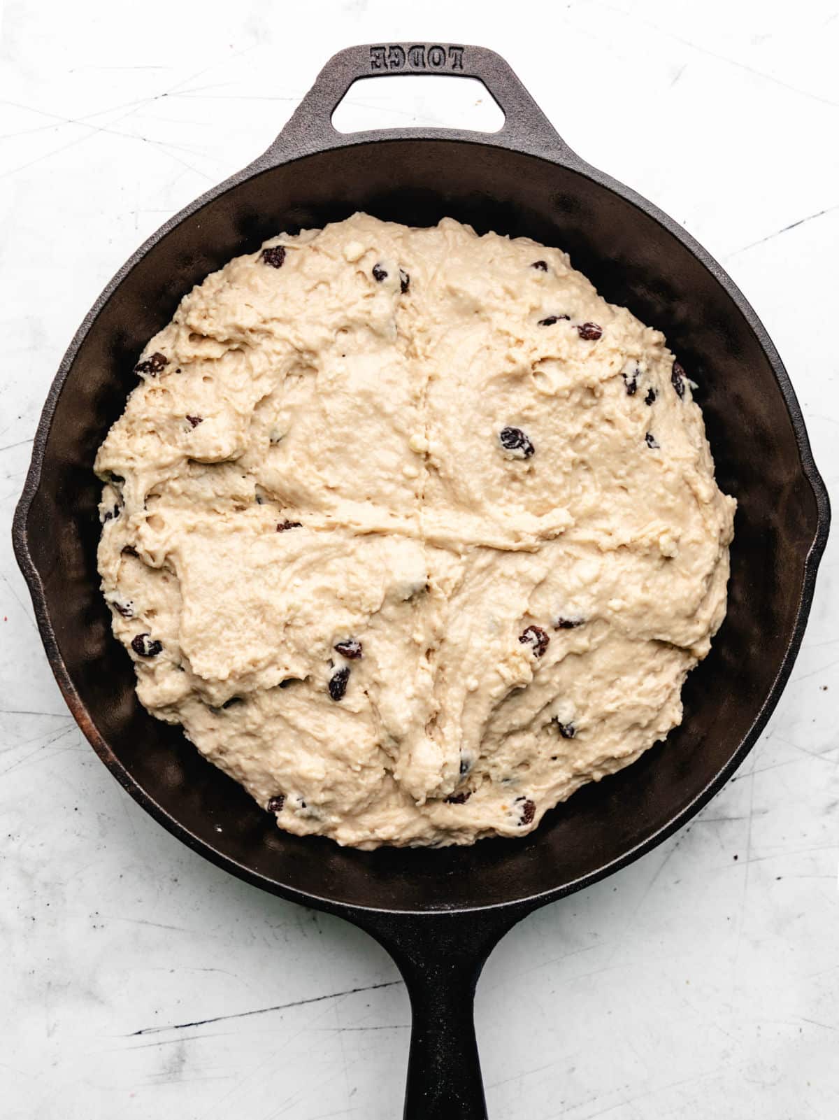 Irish soda bread dough with a cross cut into it.