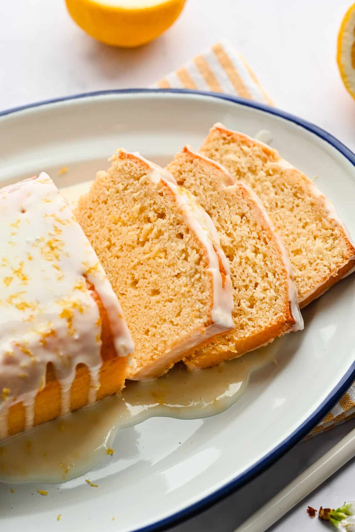 Iced Lemon Loaf Three slices of lemon loaf cake on a white platter.
