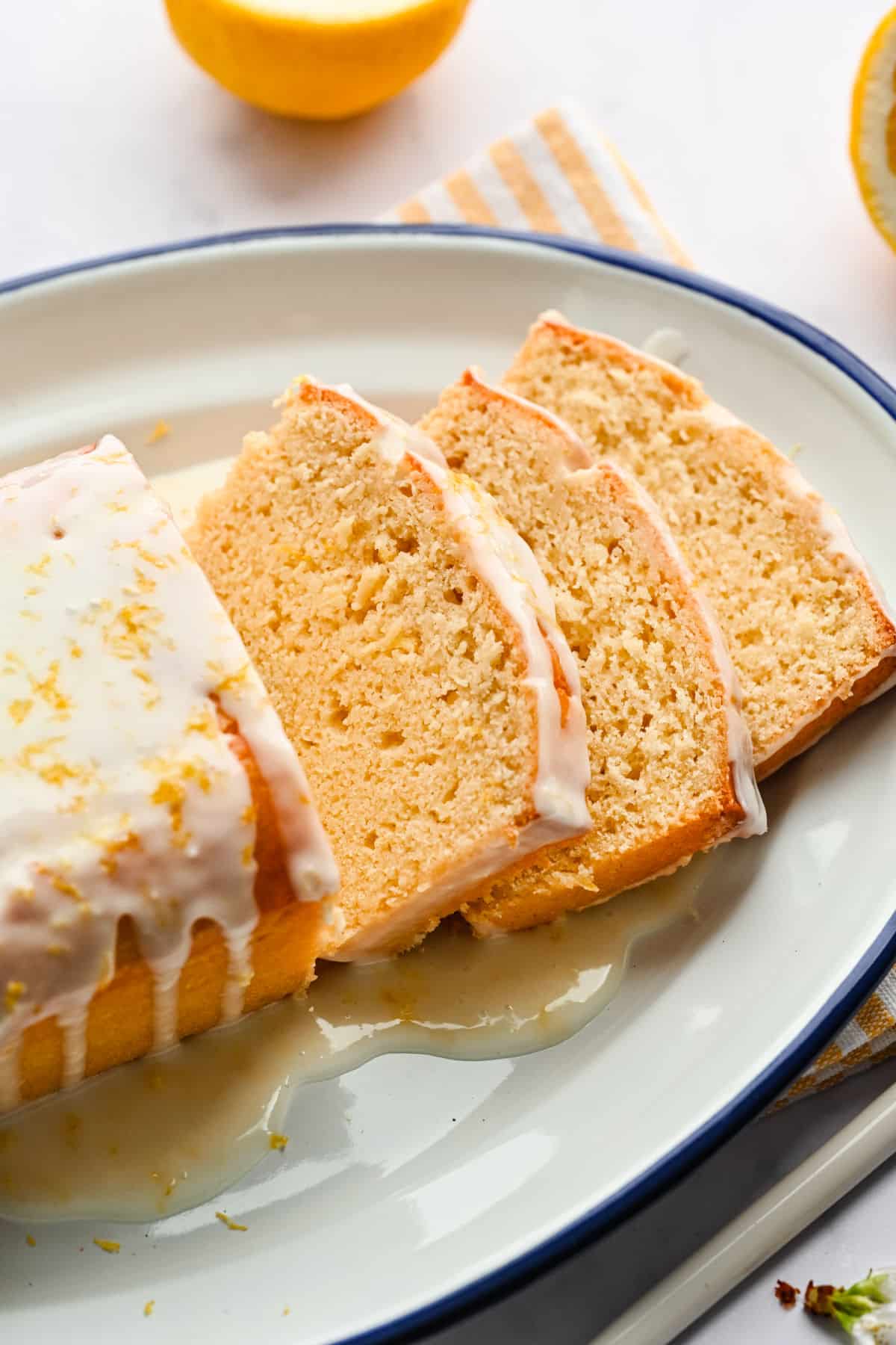 Three slices of lemon loaf cake on a white platter.