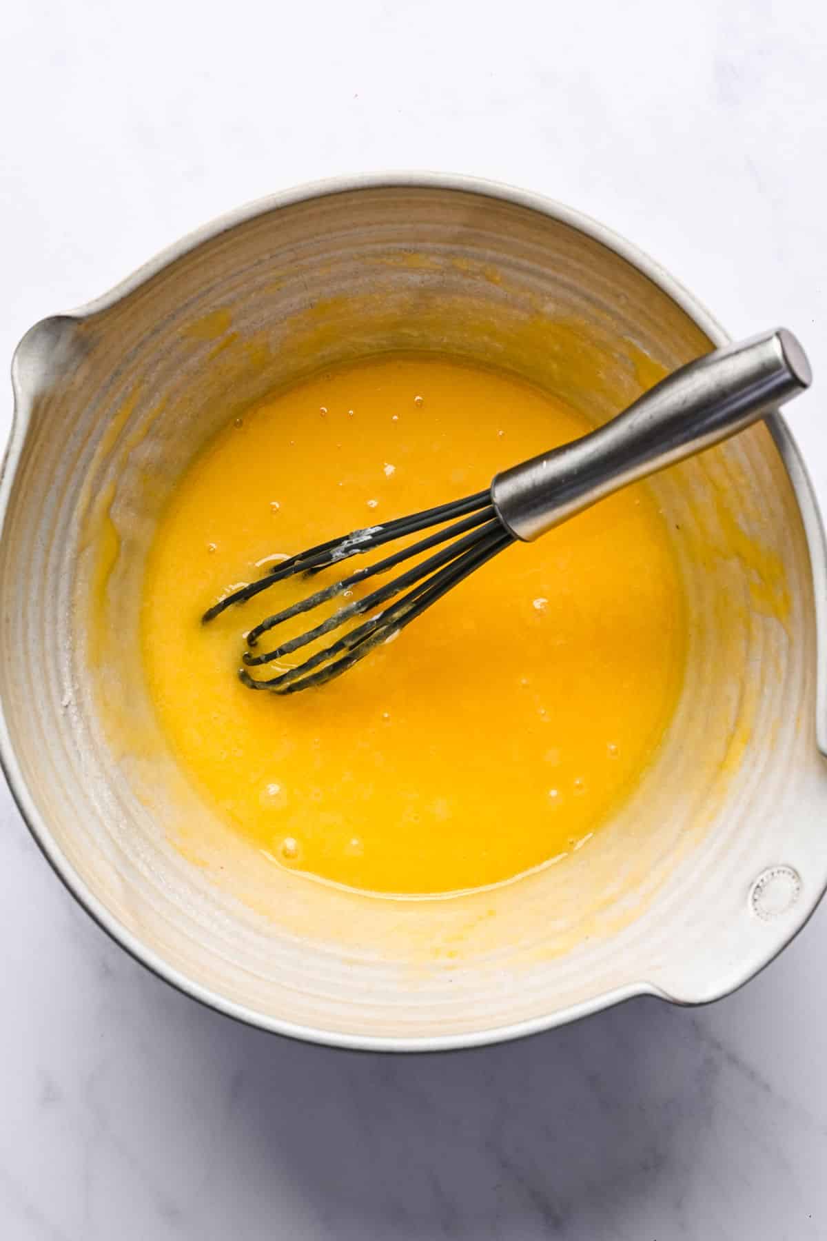 Eggs whisked into lemon oil mixture.
