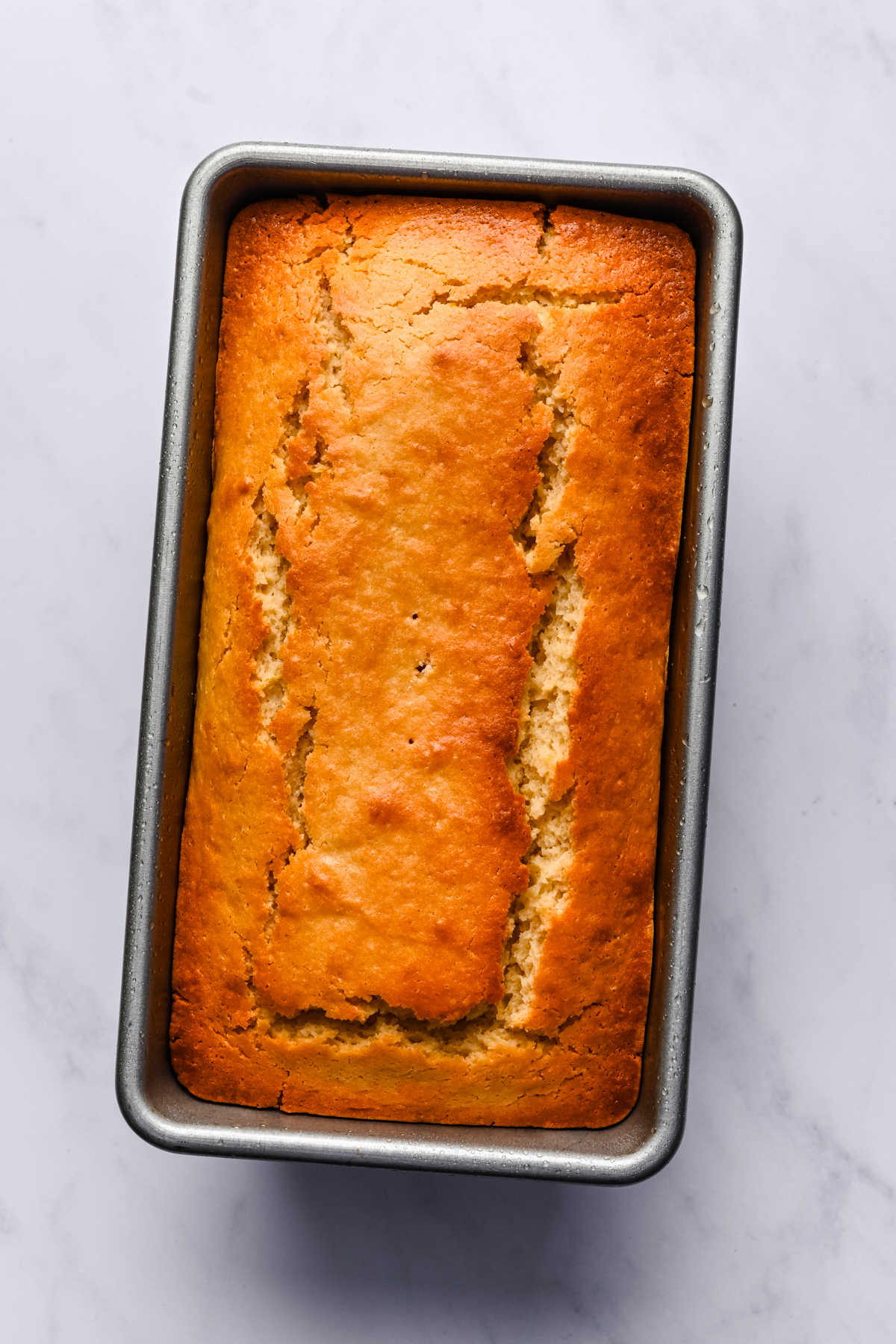 Baked lemon loaf cake in a loaf pan.