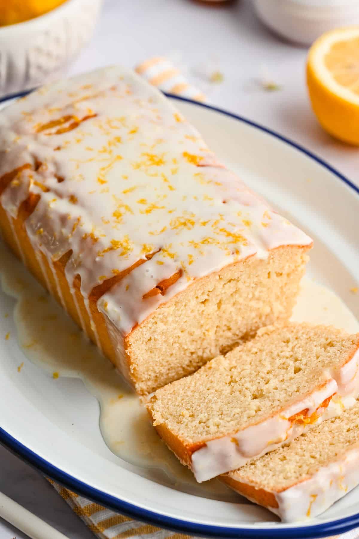 Sliced lemon loaf cake on a white platter. 