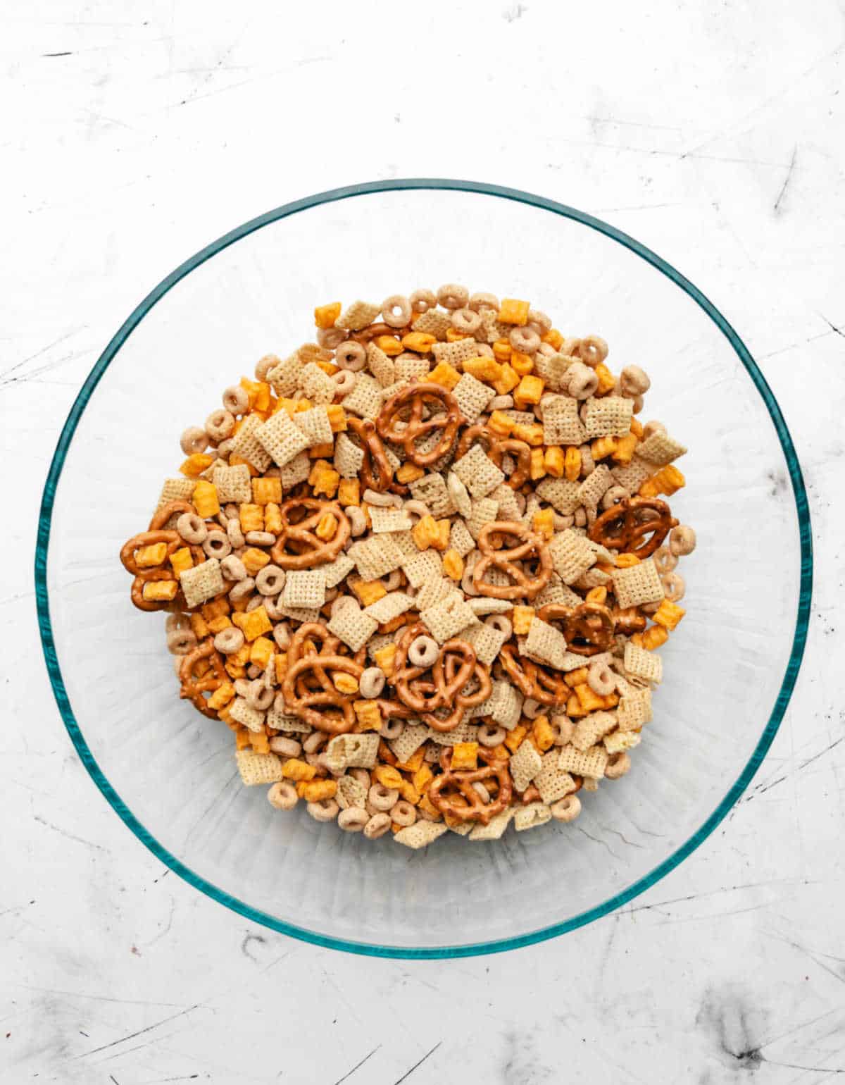 Cereals and pretzels in a glass mixing bowl. 