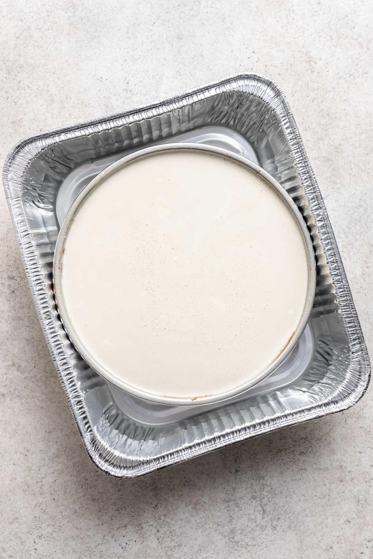 Cream cheese mixture in a round cake pan.