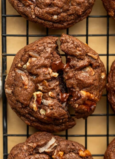 A German chocolate cookie broken in half on a wire cooling rack.