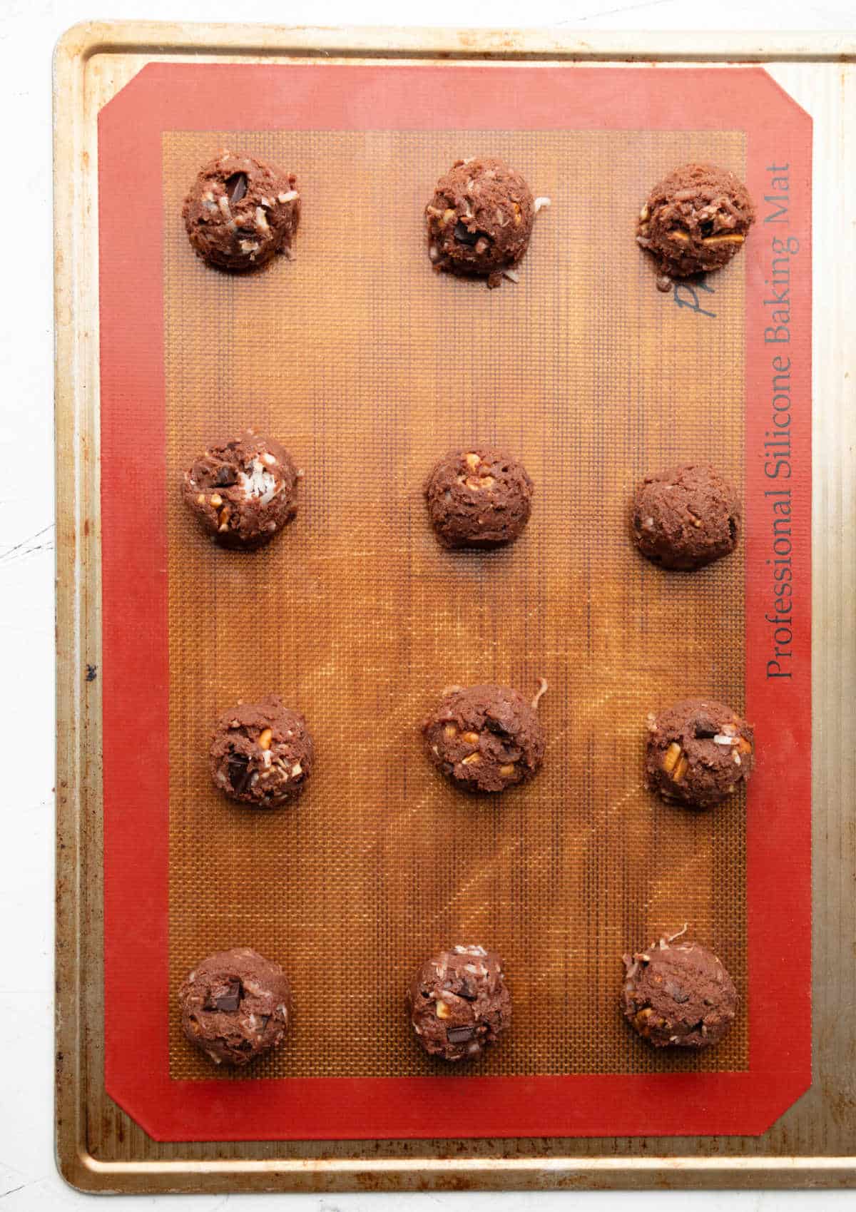 Scoops of German chocolate cookie dough on a baking sheet. 