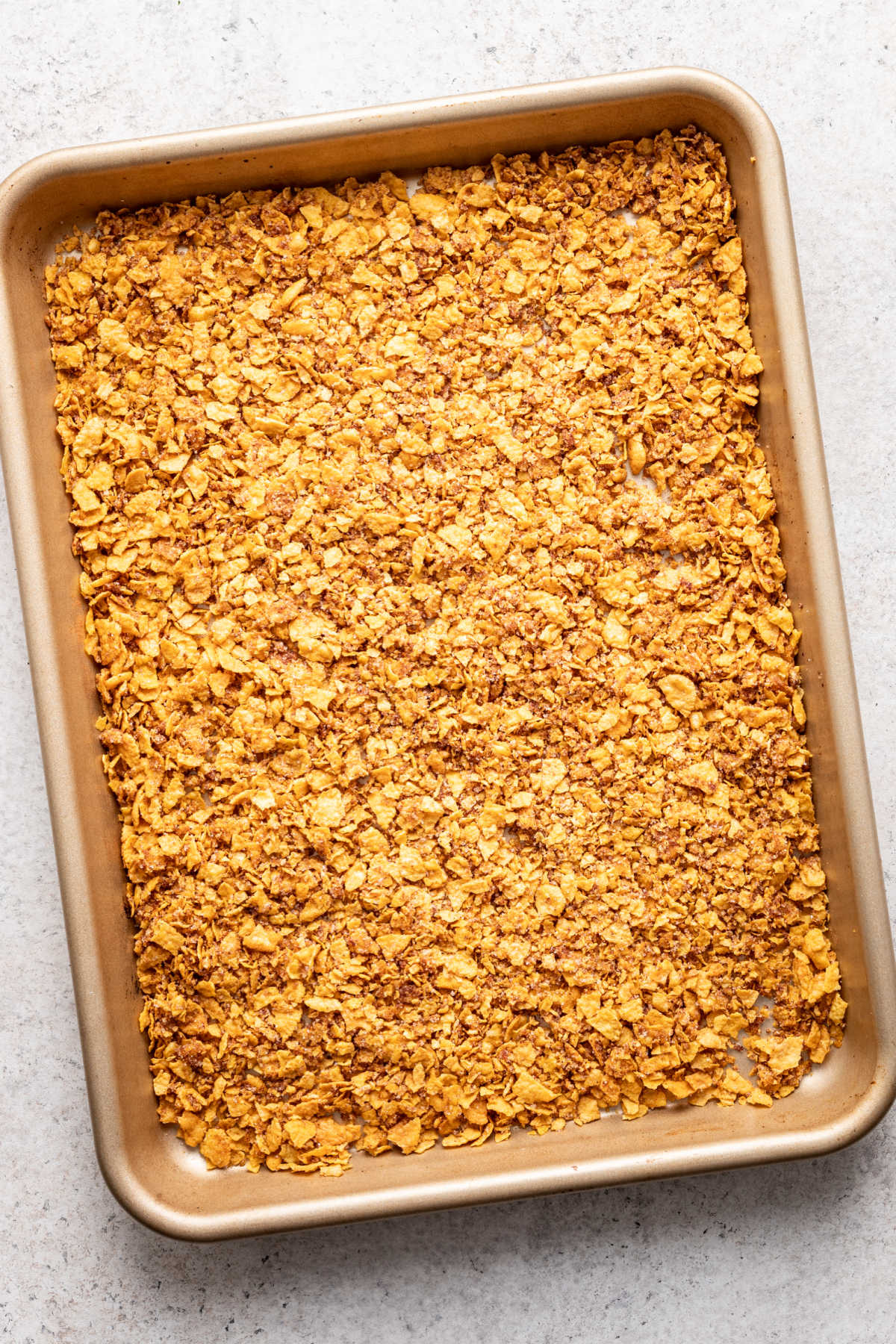 A pan of crushed cornflakes cinnamon and sugar. 