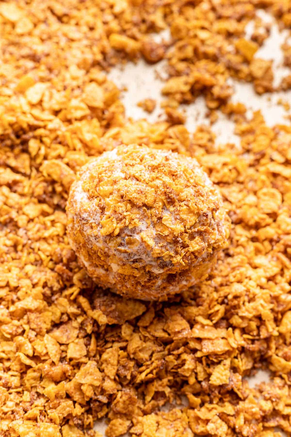 A scoop of vanilla ice cream rolled in crushed cornflake mixture. 