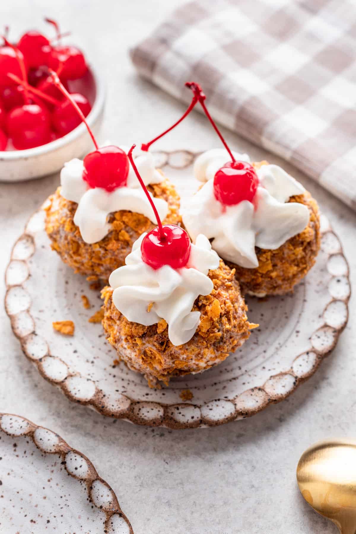 Scoops of No fry fried ice cream next to a bowl of cherries. 