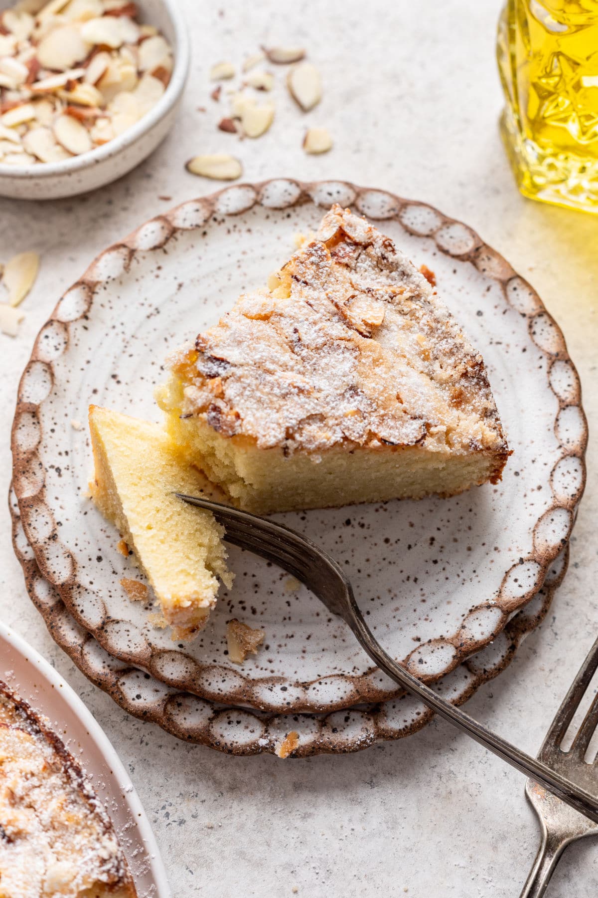 A fork taking a bite from a slice of olive oil cake.