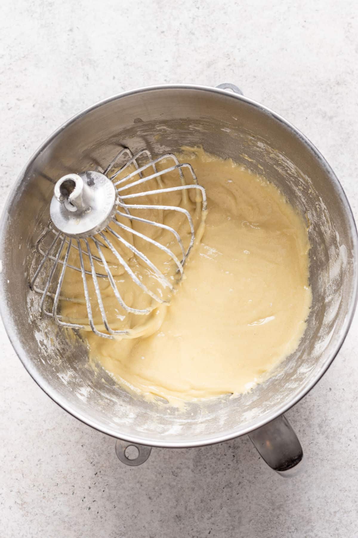 Olive oil cake batter in a silver mixing bowl.