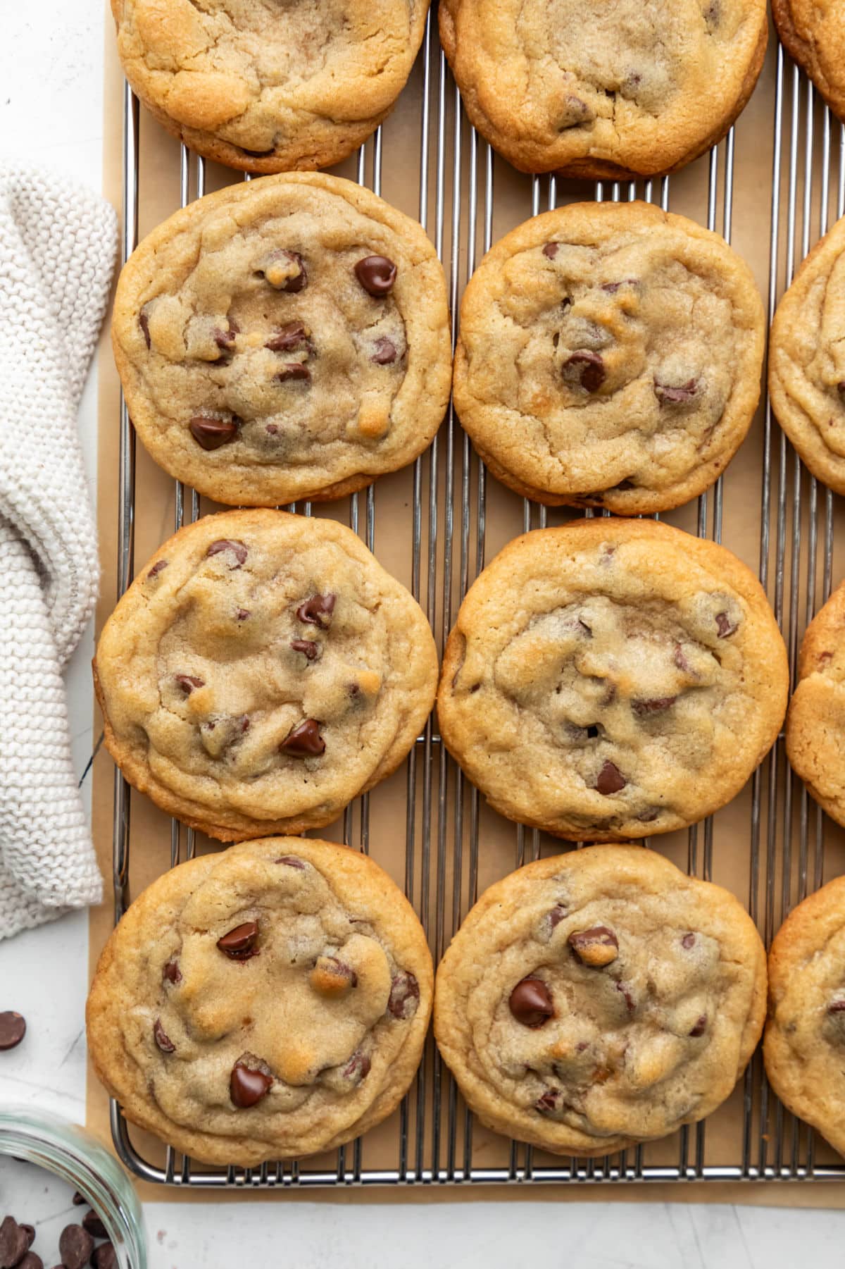 Rows of bakery style chocolate chip cookies on a wire cooling rack.