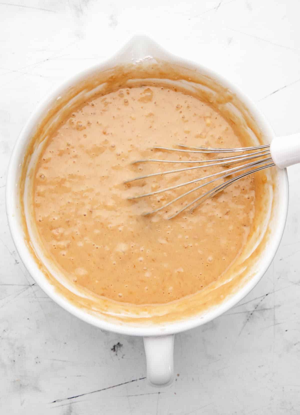 Banana muffin batter in a white mixing bowl. 