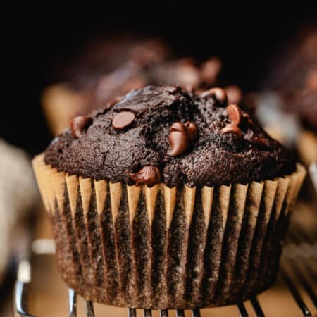 Double chocolate chip muffins on a wire cooling rack.