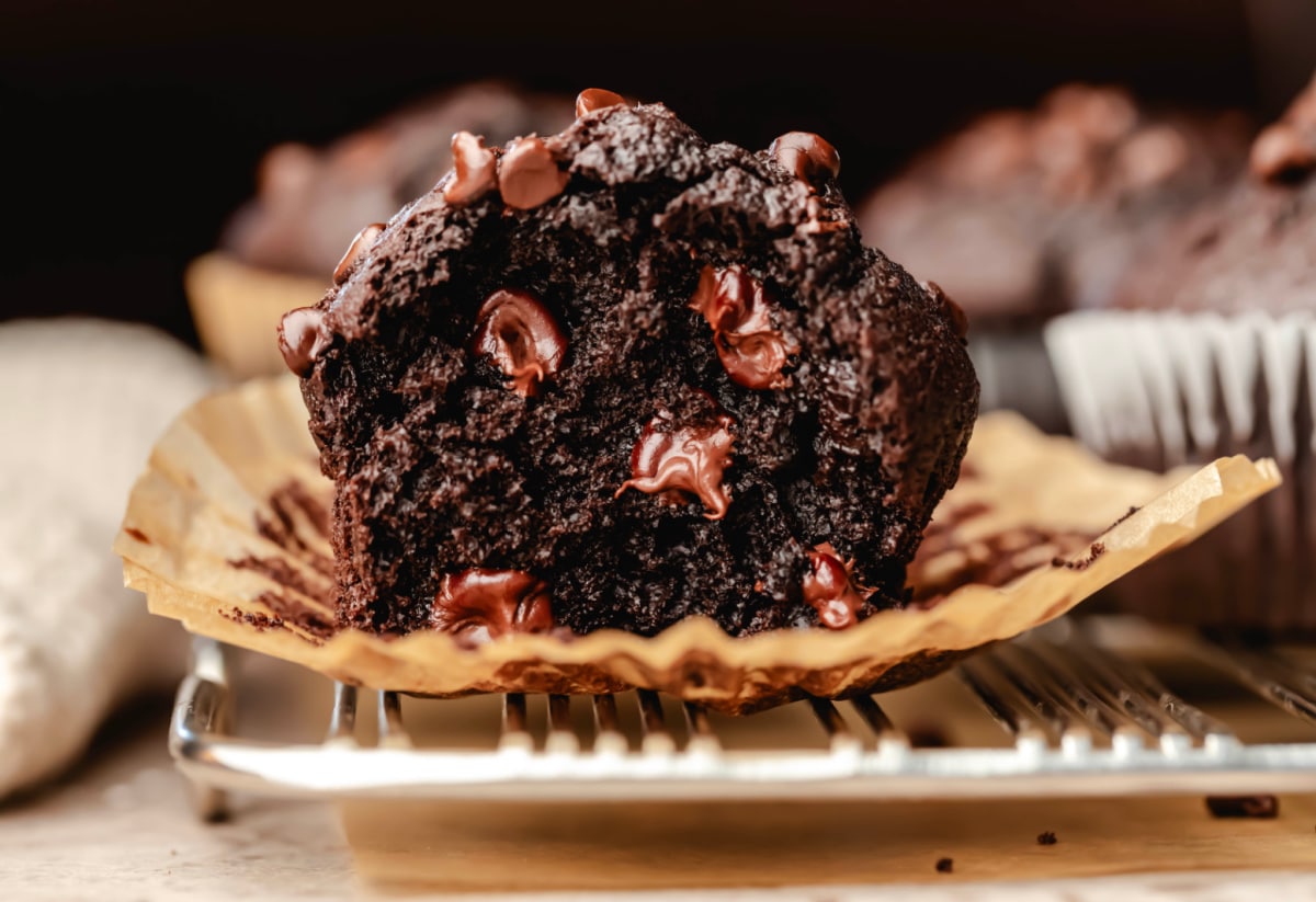 Half of a double chocolate chip muffin in a parchment paper muffin liner. 